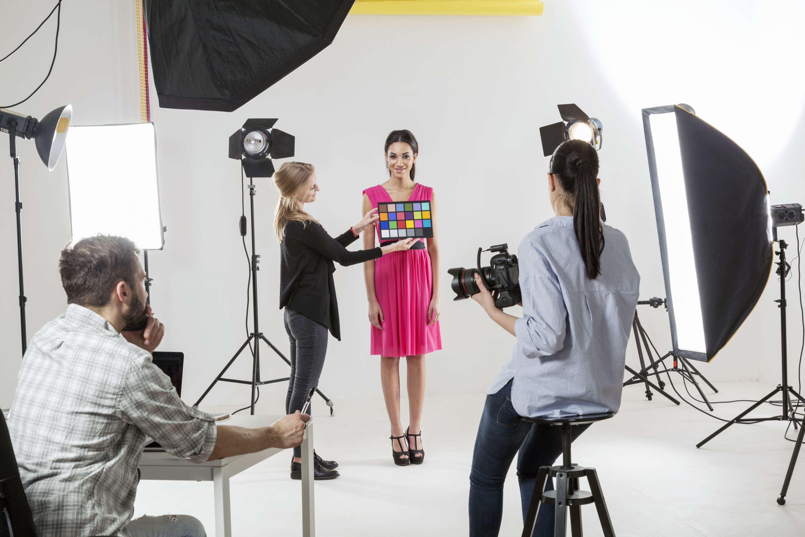Photographer checking colour setting in white backdrop photography studio shoot