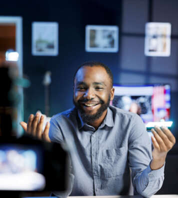Cheerful internet show host reviewing mini RGB lights, satisfied with special effects modes options. Media star excited about excellent adjustable colors on video production tool